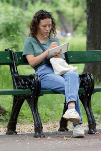 Girl sitting on a bench and writing